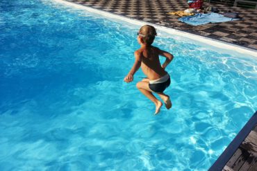 Kind springt in Pool